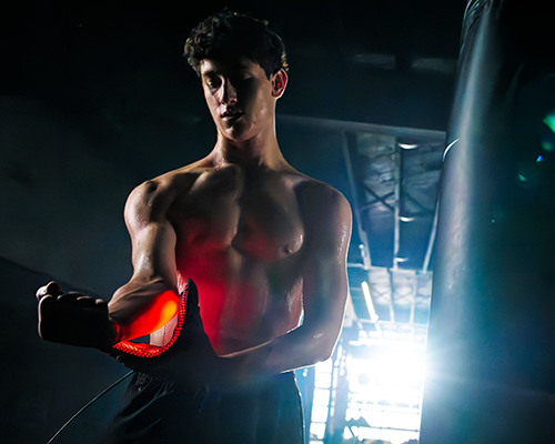 Man in a boxing ring using red light device by DNA Vibe