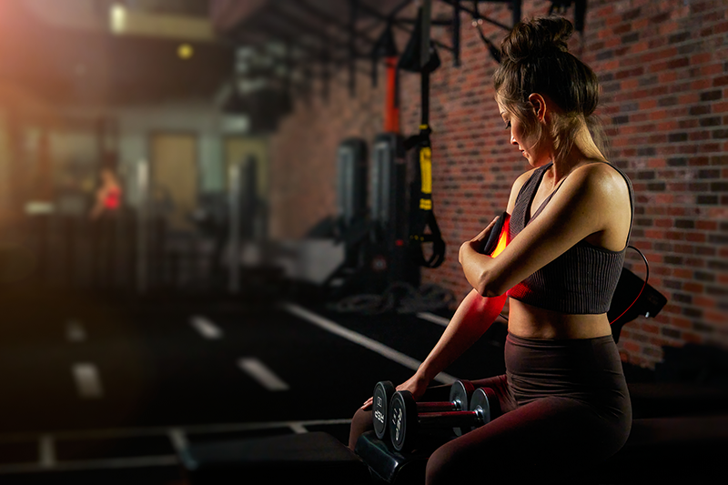 Woman exercising with dumbbells in a gym setting