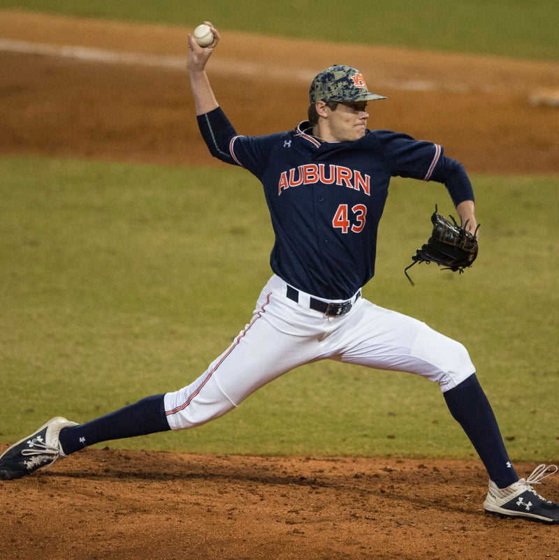 Baseball player in Auburn uniform pitching on a field